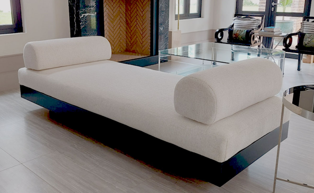 Modern custom daybed with sleek black base and textured white **bespoke upholstery** featuring rounded **custom cushions**, handcrafted by edge.ids in Johannesburg.