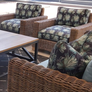 Luxury wicker patio seating with coordinated **custom cushions** in weather-resistant leaf patterns and **bespoke upholstery** by edge.ids Johannesburg.
