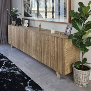 Long handcrafted timber credenza with fluted wood texture and integrated cabinet doors, showcasing **bespoke furniture** and technical joinery by edge.ids Johannesburg.
