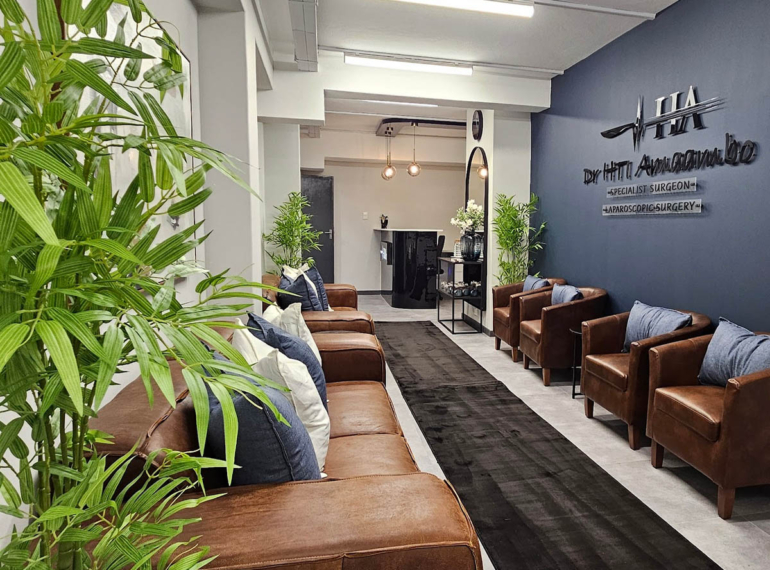A professional medical suite waiting room featuring leather seating, custom lighting, and a branded reception area designed and styled by edge.ids.