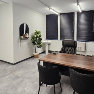 A professional doctor’s private office featuring a modern timber desk, executive seating, and architectural Venetian blinds styled by edge.ids.